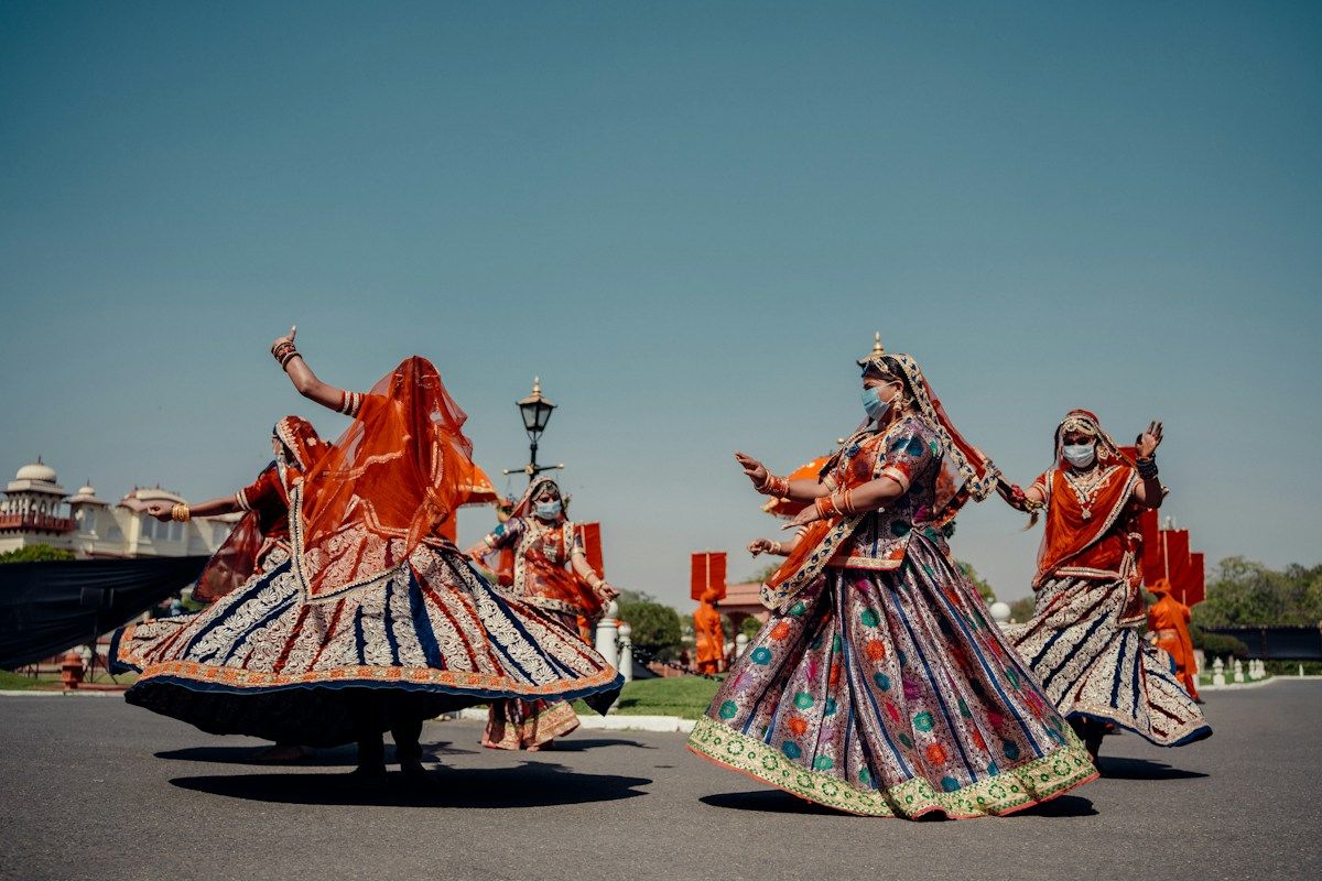 Women in swirling ghagras dancing in an open courtyard